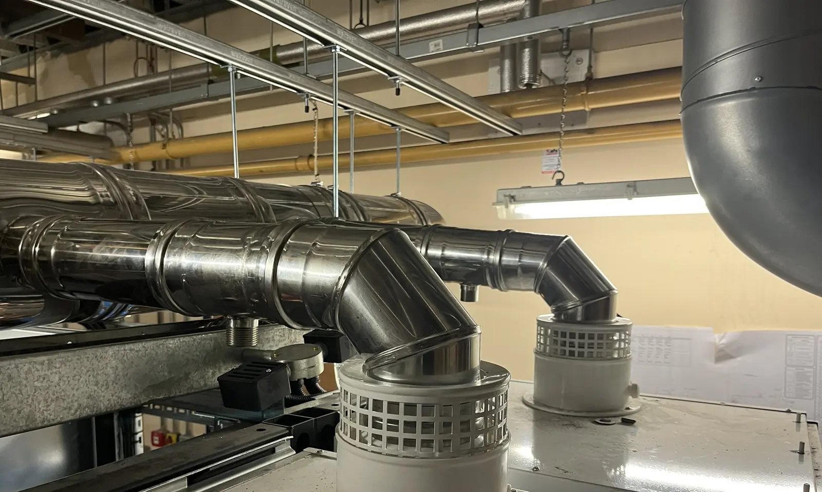 Boiler flue header and connections above the boilers in the plant room